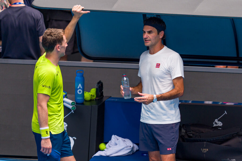 Roger Federer (R) of Switzerland speaks to Casper Ruud of Norway after a practice session ahead of the 2026 Australian Open at Melbourne Park on January 16, 2026 in Melbourne, Australia.