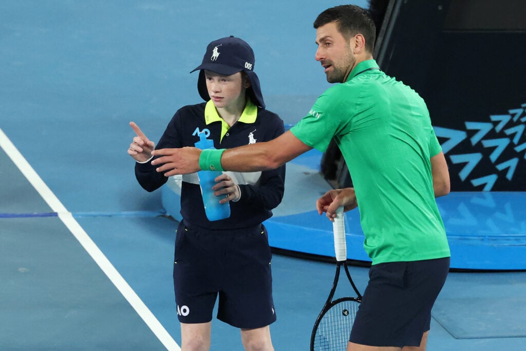 Serbia's Novak Djokovic talks to a ball kid during the men's singles match against Netherlands' Botic van de Zandschulp on day seven of the Australian Open tennis tournament in Melbourne on January 24, 2026.