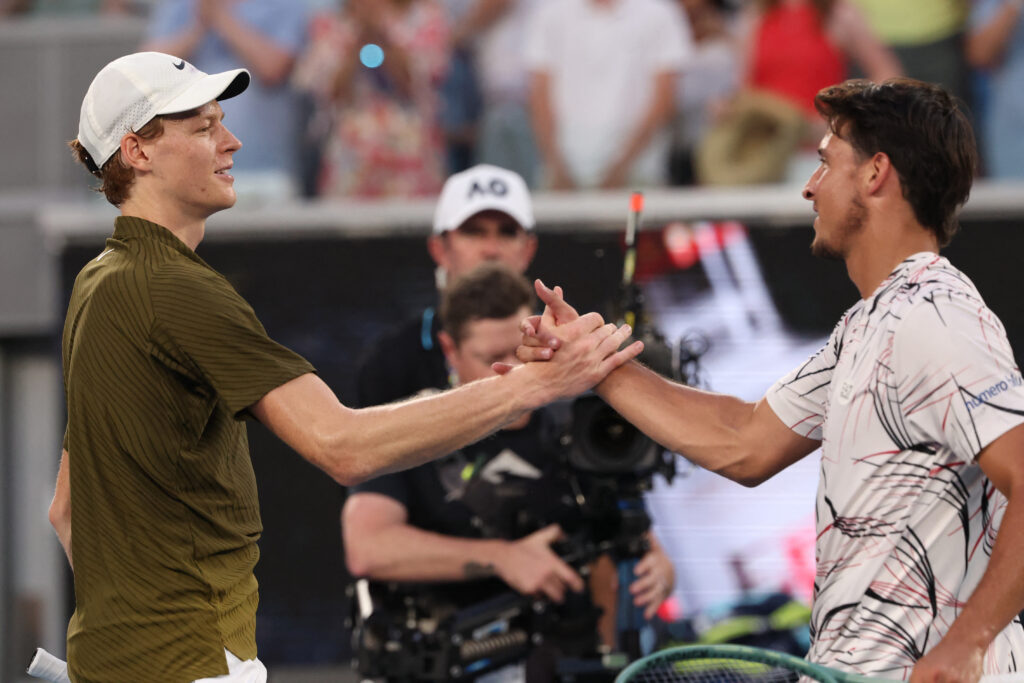 Italy's Jannik Sinner (L) greets Italy's Luciano Darderi after winning their men's singles match on day nine of the Australian Open tennis tournament in Melbourne on January 26, 2026.