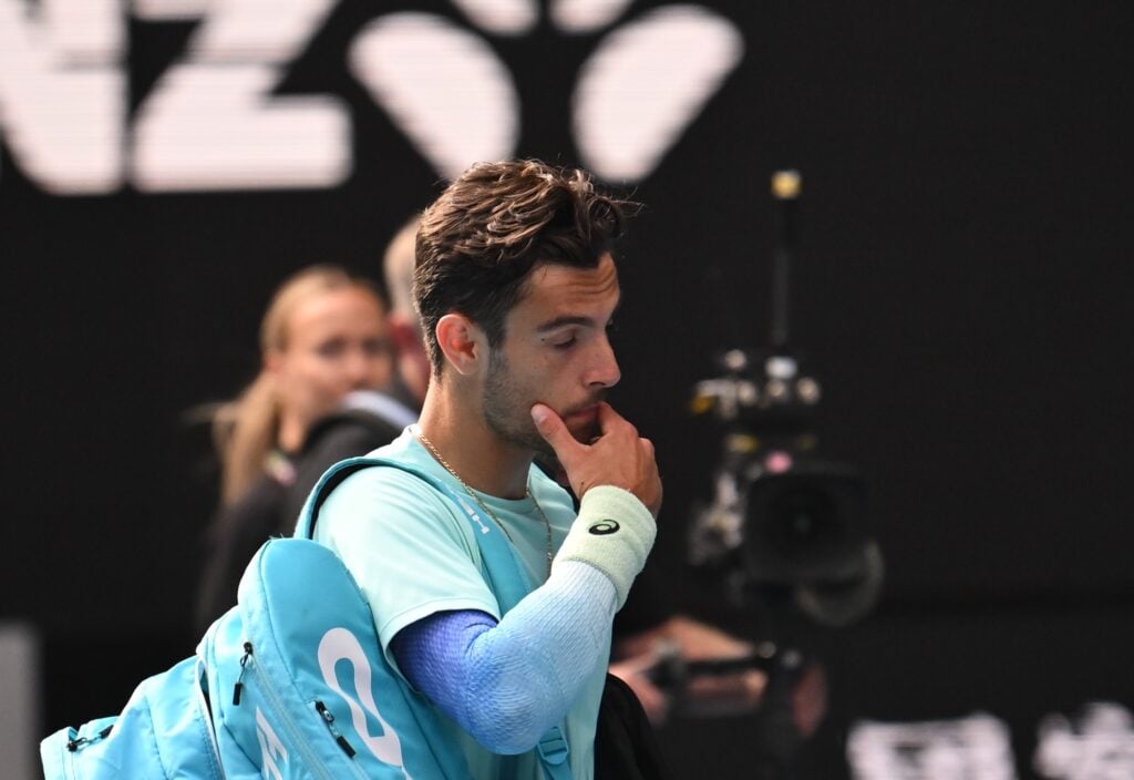 Lorenzo Musetti of Italy reacts after retiring from the Men's Singles Quarterfinal against Novak Djokovic of Serbia during day 11 of the 2026 Australian Open at Melbourne Park on January 28, 2026 in Melbourne, Australia.