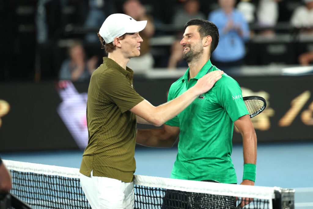 Serbia's Novak Djokovic (R) embraces Italy's Jannik Sinner after their men's singles semi-final match on day thirteen of the Australian Open tennis tournament in Melbourne on January 31, 2026.
