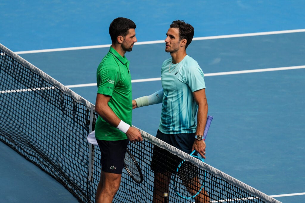 Lorenzo Musetti (R) of Italy greets Novak Djokovic of Serbia after Musetti retired due to injury in the Men's Singles Quarter Finals match during day eleven of the 2026 Australian Open at Melbourne Park on January 28, 2026 in Melbourne, Australia.