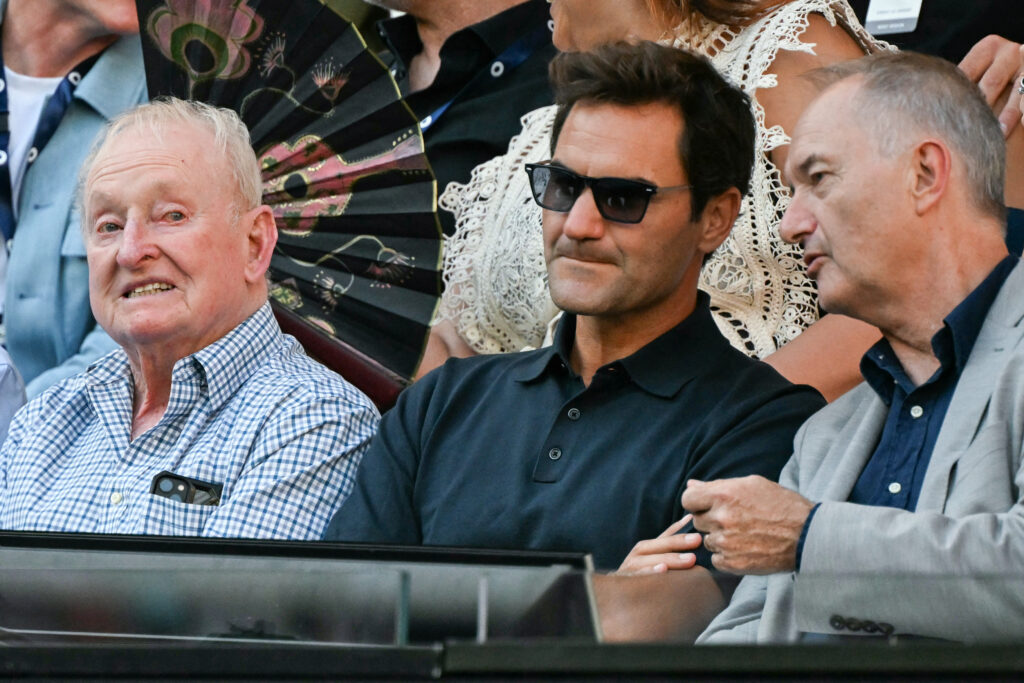 Switzerland's Roger Federer (C) and Australia's Rod Laver (L) watch a match during day one of the Australian Open tennis tournament in Melbourne on January 18, 2026.