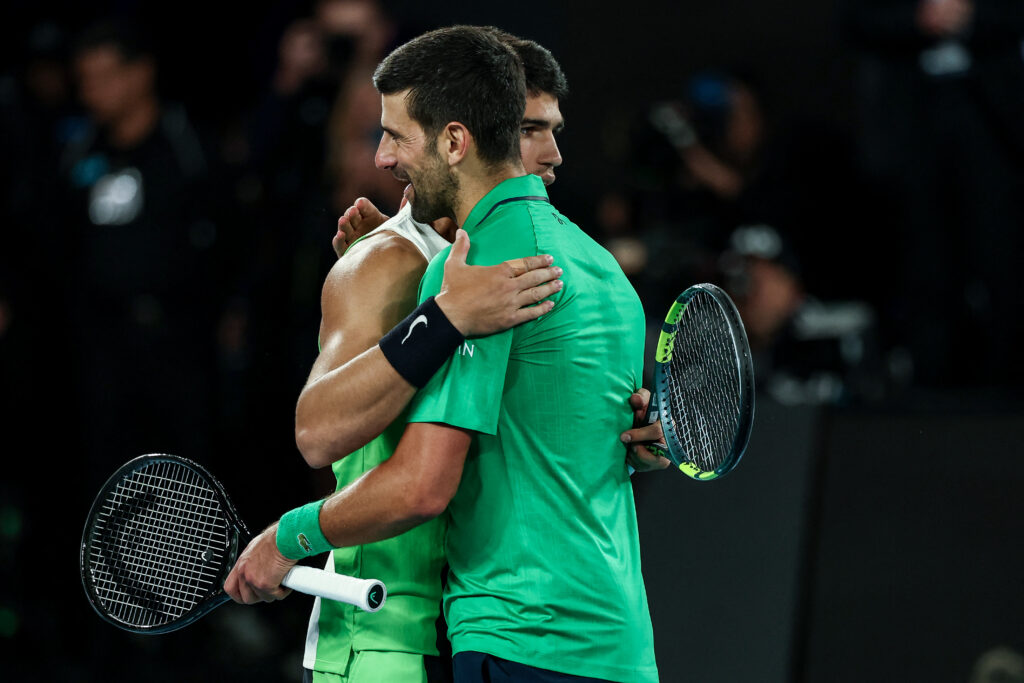 Spain's Carlos Alcaraz (L) greets Serbia's Novak Djokovic after winning their men's singles final match on day fifteen of the Australian Open tennis tournament in Melbourne on February 1, 2026.