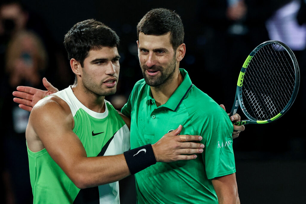 Spain's Carlos Alcaraz (L) greets Serbia's Novak Djokovic after winning their men's singles final match on day fifteen of the Australian Open tennis tournament in Melbourne on February 1, 2026.