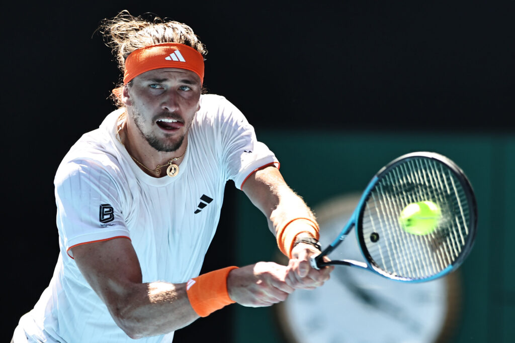 Germany's Alexander Zverev hits a return in the men's singles semi-final match against Spain's Carlos Alcaraz on day 13 of the 2026 Australian Open at Melbourne Park on January 30, 2026 in Melbourne, Australia.