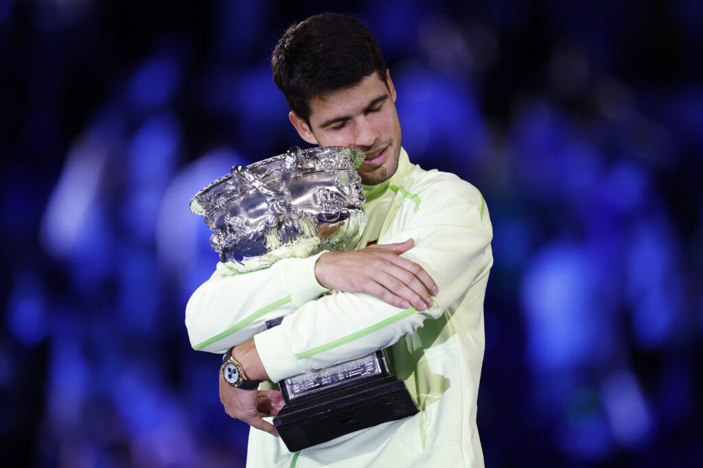 Carlos Alcaraz of Spain hugs the Norman Brookes Challenge Cup at the presentation ceremony after his victory in the Men's Singles Final against Novak Djokovic of Serbia during day 15 of the 2026 Australian Open at Melbourne Park on February 01, 2026 in Melbourne, Australia.