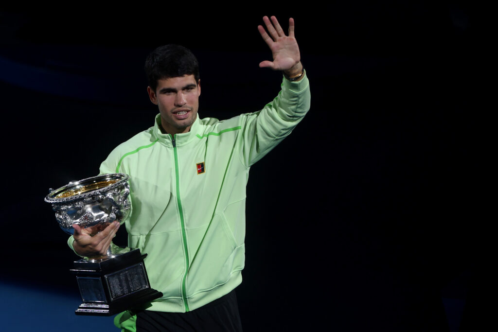 Carlos Alcaraz waves with his trophy