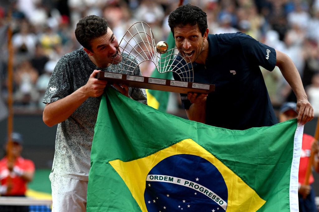 Brazil's couple Marcelo Melo (L) and Joao Fonseca pose with the tropy after winning their men's doubles final match against Netherlands's Robin Haase (L) and Germany's Constantin Frantzen at the Rio Open tennis tournament in Rio de Janeiro, Brazil, on February 22, 2026.