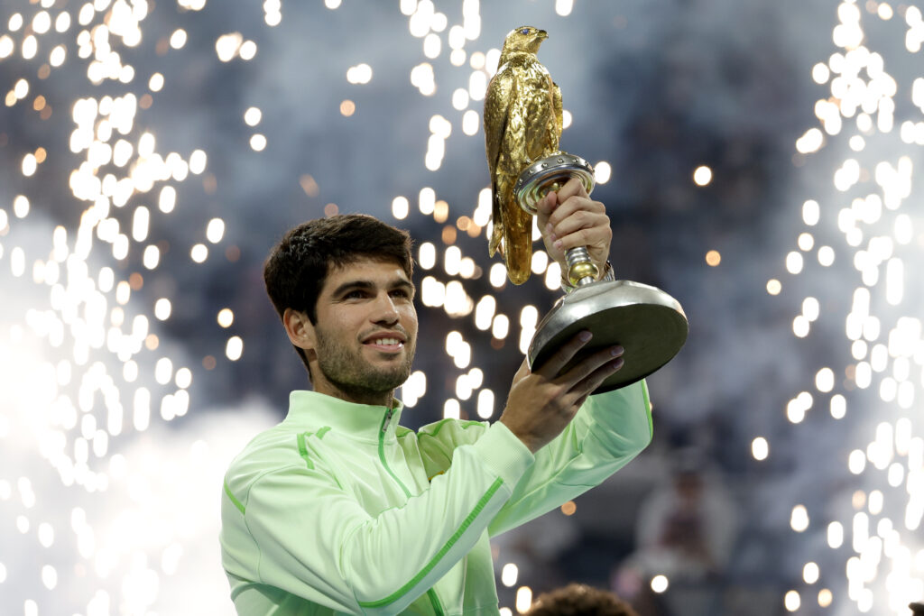 Carlos Alcaraz of Spain celebrates with the trophy after winning his men's singles final match against Arthur Fils of France at the Qatar ExxonMobil Open at Khalifa International Tennis and Squash Complex on February 21, 2026 in Doha, Qatar.