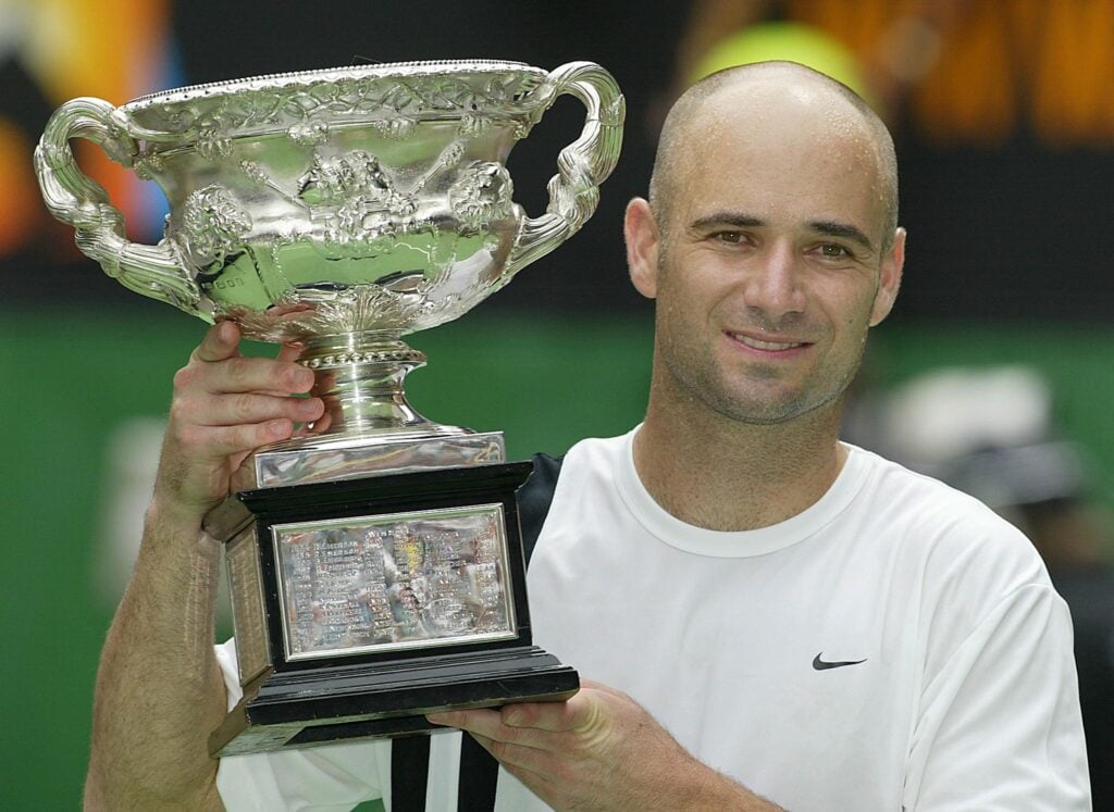 Andre Agassi of the US poses with the winner's trophy following his victory over Rainer Schuettler of Germany in the men's singles final at the Australian Open tennis tournament in Melbourne, 26 January 2003. Agassi won 6-2, 6-2, 6-1 to take his fourth Australian Open title.