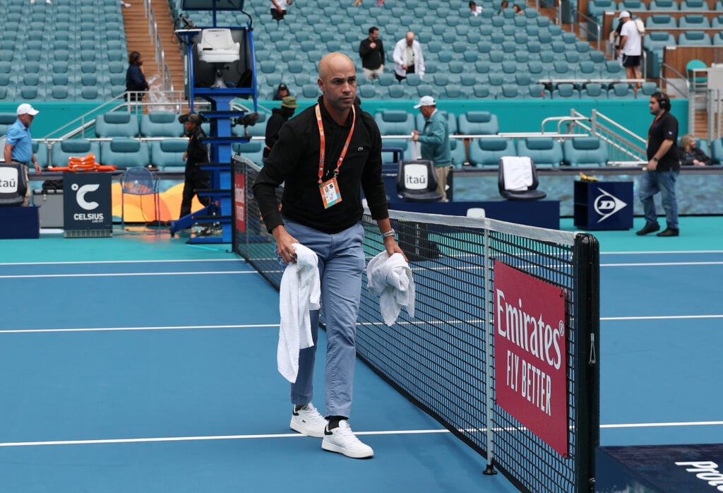 Tournament Director James Blake attempts to dry center court with towels during a rain delay prior to the match between Taylor Fritz and Thiago Seyboth Wild of Brazil on day 8 of the Miami Open at Hard Rock Stadium on March 23, 2024 in Miami Gardens, Florida.