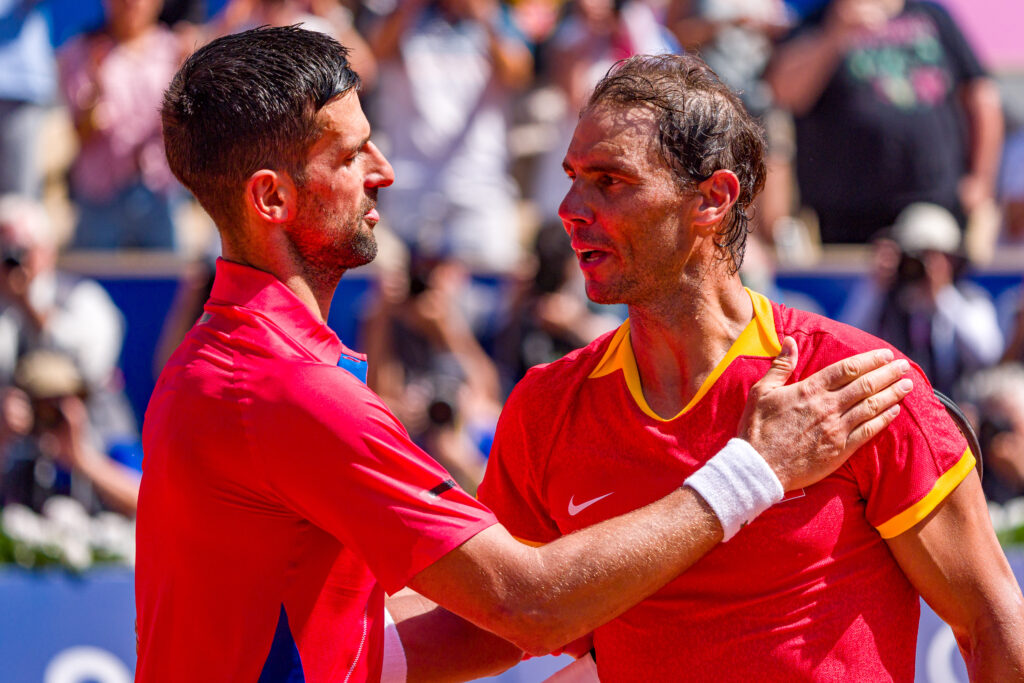 Novak Djokovic (L) of Team Serbia embraces Rafael Nadal of Team Spain after winning match point during the Men's Singles second round match on day three of the Olympic Games Paris 2024 at Roland Garros on July 29, 2024 in Paris, France.