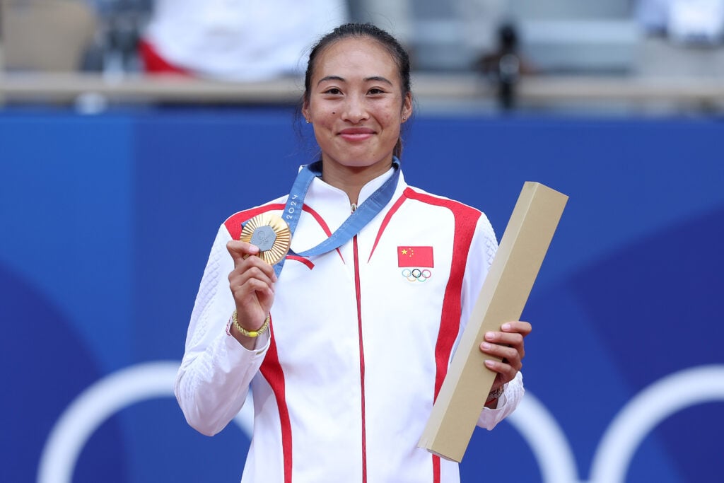 Gold medalist Qinwen Zheng of Team People’s Republic of China celebrates on the podium during the Tennis Women's Singles medal ceremony after the Tennis Women's Singles Gold Medal match on day eight of the Olympic Games Paris 2024 at Roland Garros on August 03, 2024 in Paris, France.