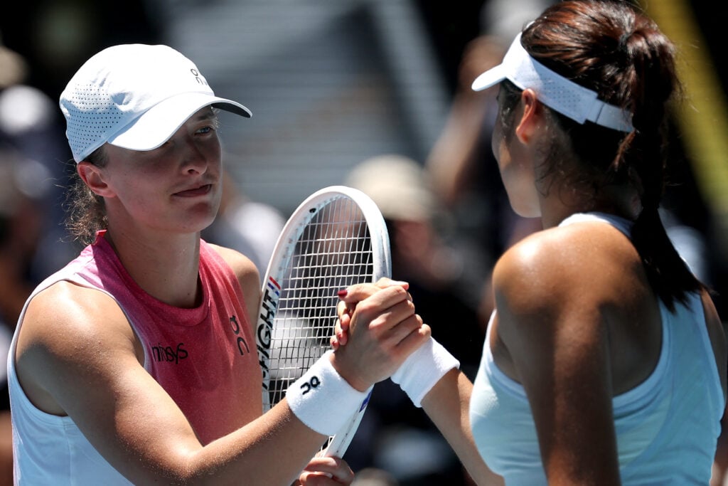 Poland's Iga Swiatek (L) shakes hands with Britain's Emma Raducanu after their women's singles match on day seven of the Australian Open tennis tournament in Melbourne on January 18, 2025.