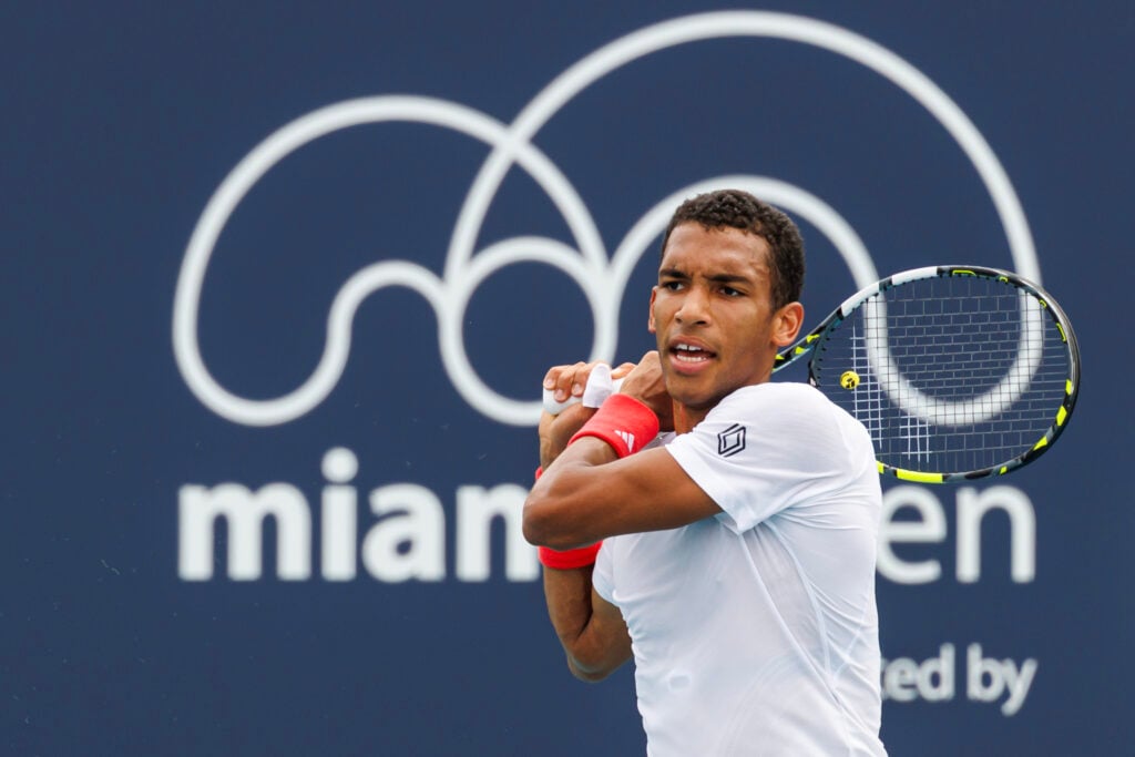 Felix Auger-Aliassime of Canada hits a backhand against Lorenzo Musetti of Italy in the third round of the men's singles in the Miami Open at the Hard Rock Stadium on March 23, 2025 in Miami Gardens, Florida.