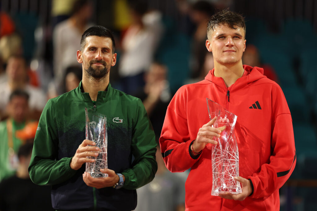 Novak Djokovic of Serbia and Jakub Mensik of the Czech Republic pose with their trophies following the men's singles final on the final day of the Miami Open Presented by Itau 2025 at Hard Rock Stadium on March 30, 2025 in Miami Gardens, Florida.
