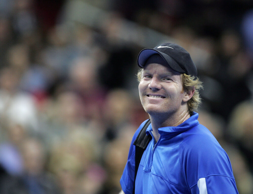 Jim Courier smiles at the crowd while leaving the court during the Serving for Tsunami Relief tennis match at Toyota Center in Houston, Texas. Tennis Champion's Jim Courier, John McEnroe, Chris Evert, Andy Roddick, Anna Kournikova and Tommy Haas wear among professional players who played with celebrities Dr. Phil McGraw and Clyde Drexler.