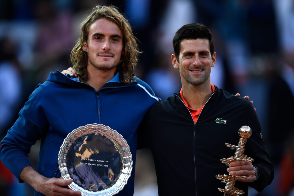 Serbia's Novak Djokovic (R) and Greece's Stefanos Tsitsipas (L) pose on the podium of the ATP Madrid Open final tennis match at the Caja Magica in Madrid on May 12, 2019.