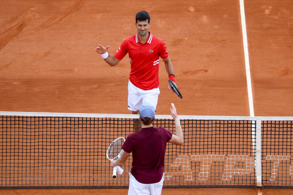 Serbia's Novak Djokovic (Top) shahes hands with Italy's Jannik Sinner after winning in their second round singles match on day five of the Monte-Carlo ATP Masters Series tournament in Monaco on April 14, 2021.