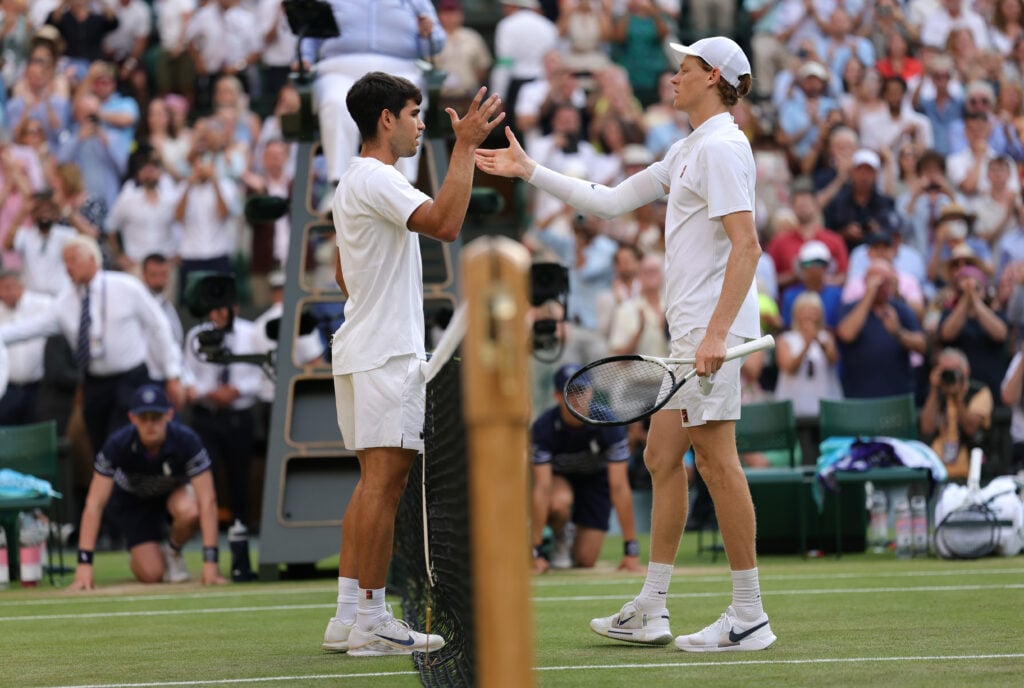Jannik Sinner of Italy meets Carlos Alcaraz of Spain at the net following victory during the Gentlemen's Singles Final on day fourteen of The Championships Wimbledon 2025 at All England Lawn Tennis and Croquet Club on July 13, 2025 in London, England.