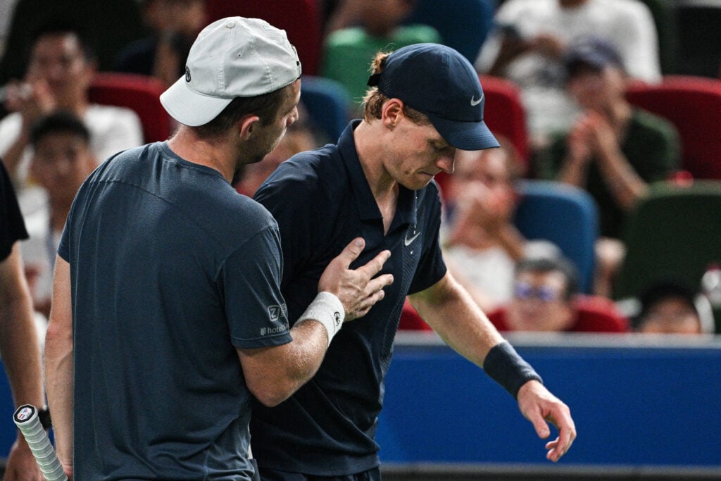 Italy's Jannik Sinner (R) reacts as he retires from his men's singles match against Netherlands' Tallon Griekspoor (L) at the Shanghai Masters tennis tournament in Shanghai on October 6, 2025.