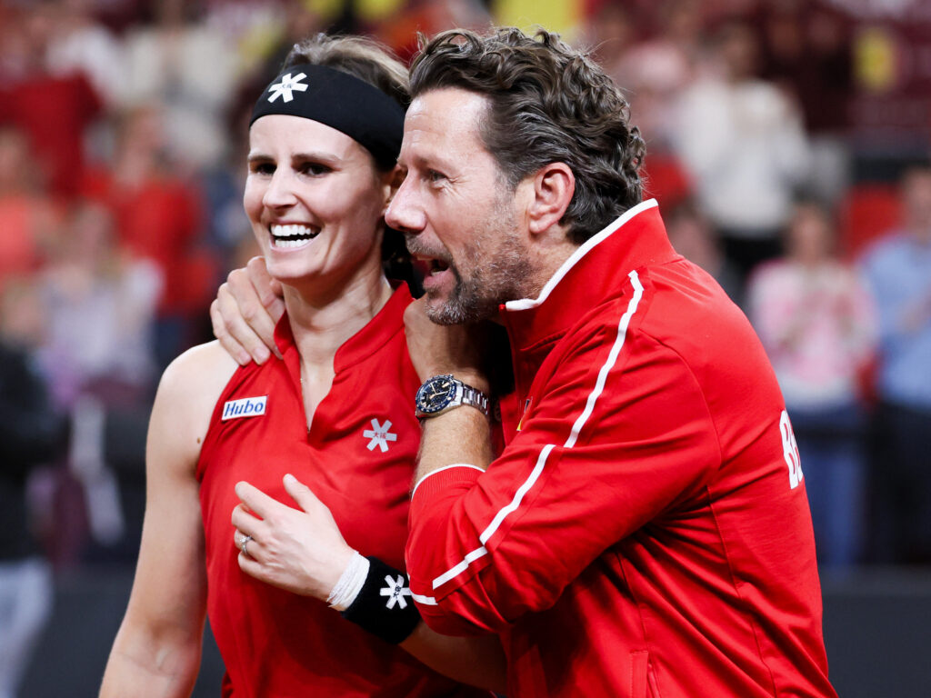 Belgium's Greet Minnen (L) celebrates alongside team's coach Wim Fissette after winning her match against USA's Iva Jovic during the Billie Jean King Cup tennis play-offs in Ostend on April 11, 2026.