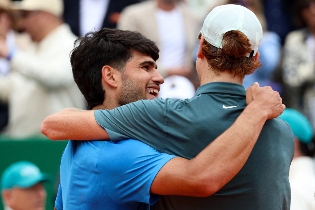 Italy's Jannik Sinner (R) embraces with Spain's Carlos Alcaraz after winning the Monte Carlo ATP Masters Series Tournament final tennis match on Court Rainier III at the Monte-Carlo Country Club in Roquebrune-Cap-Martin, south-eastern France on April 12, 2026.