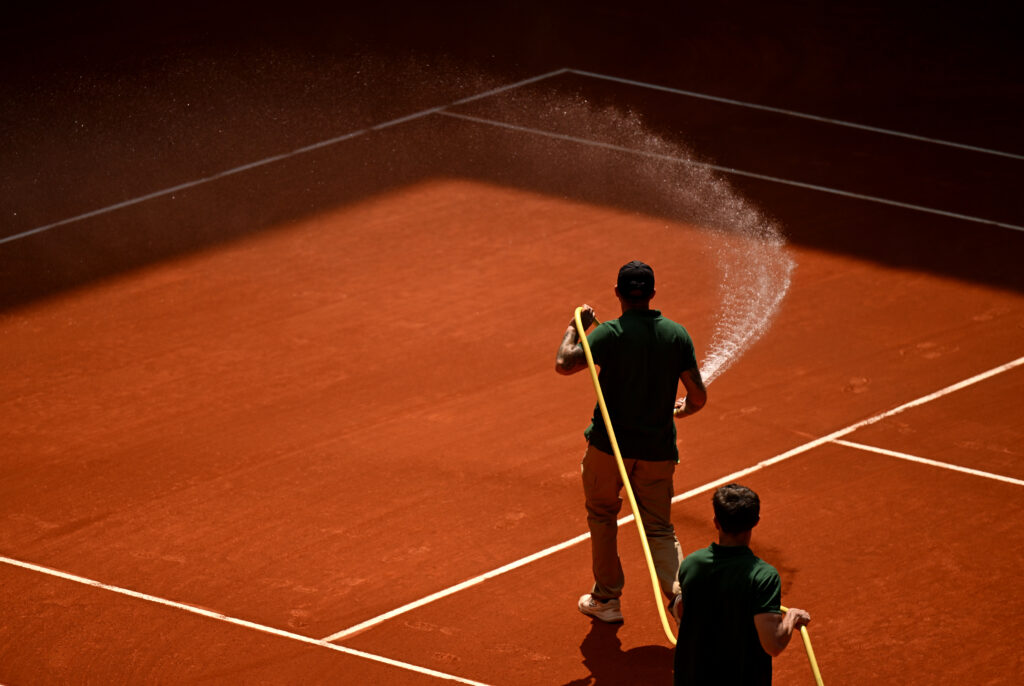 A member of the groundstaff waters the court surface during a break on day five of the Mutua Madrid Open at La Caja Magica on April 24, 2026 in Madrid, Spain.