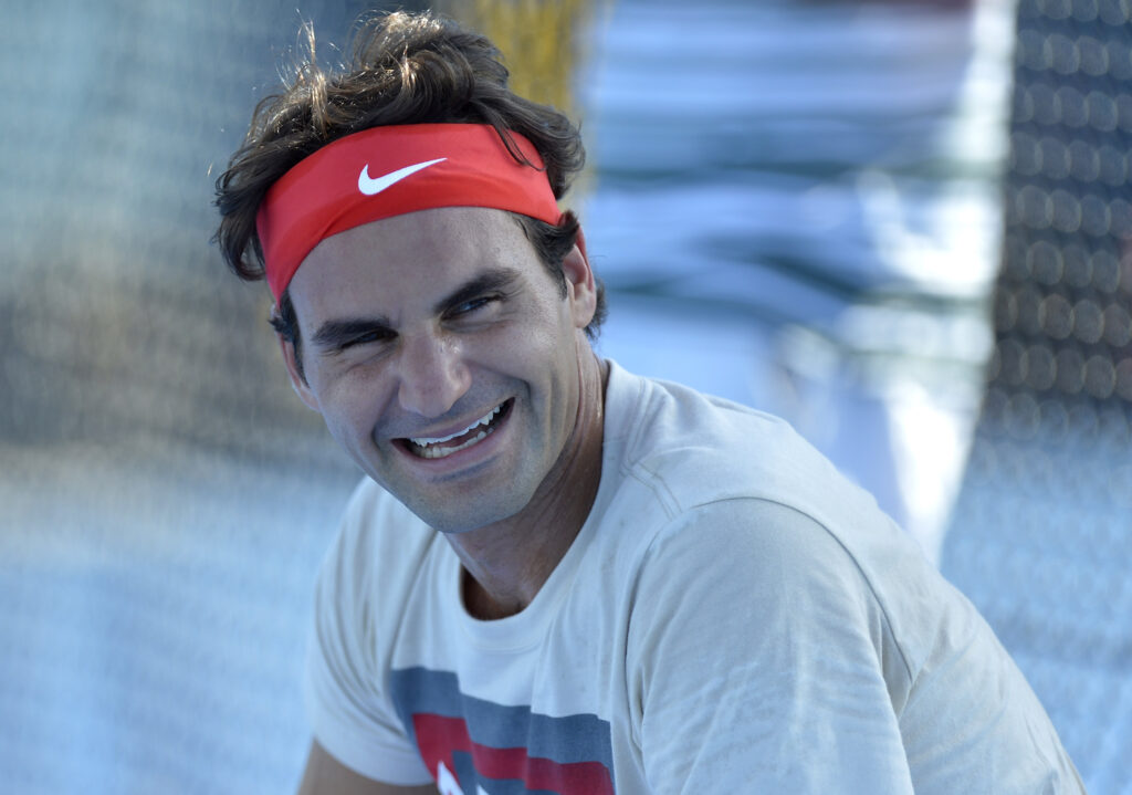Roger Federer of Switzerland has a laugh with Lleyton Hewitt during their practice session during day one of the 2014 Brisbane International at Queensland Tennis Centre on December 29, 2013 in Brisbane, Australia.