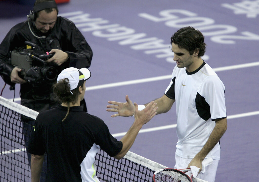 Roger Federer of Switzerland shakes hands at the net after his 6-0 6-0 victory against Gaston Gaudio of Argentina in his semi-final at the Tennis Masters Cup , at the Qi Zhong Stadium , November 19, 2005 in Shanghai, China.