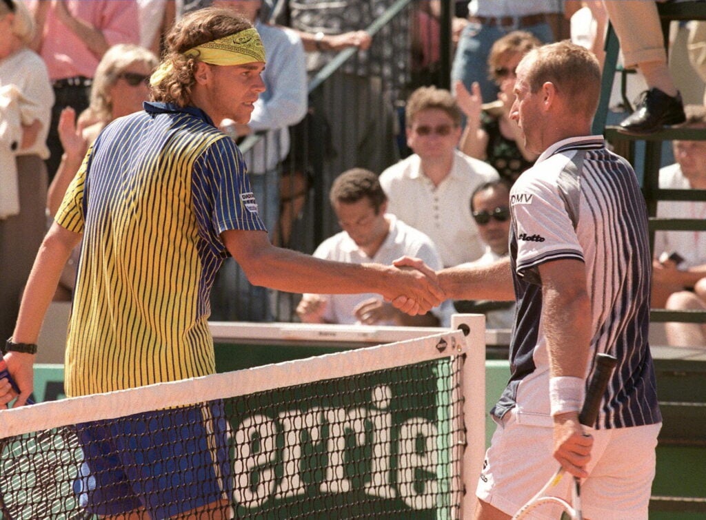 Gustavo Kuerten of Brazil (L) shakes hands with fifth-seeded Austrian Thomas Muster after their third round match at the French Open 30 May. Kuerten ousted Muster in five sets 6-7 (3/7), 6-1, 6-3, 3-6, 6-4.