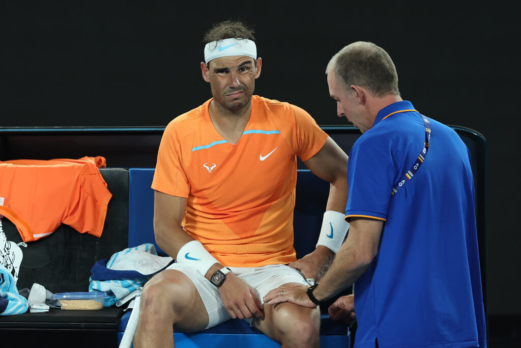 Rafael Nadal of Spain receives attention during a medical time out in their round two singles match against Mackenzie McDonald of the United States during day three of the 2023 Australian Open at Melbourne Park on January 18, 2023 in Melbourne, Australia.