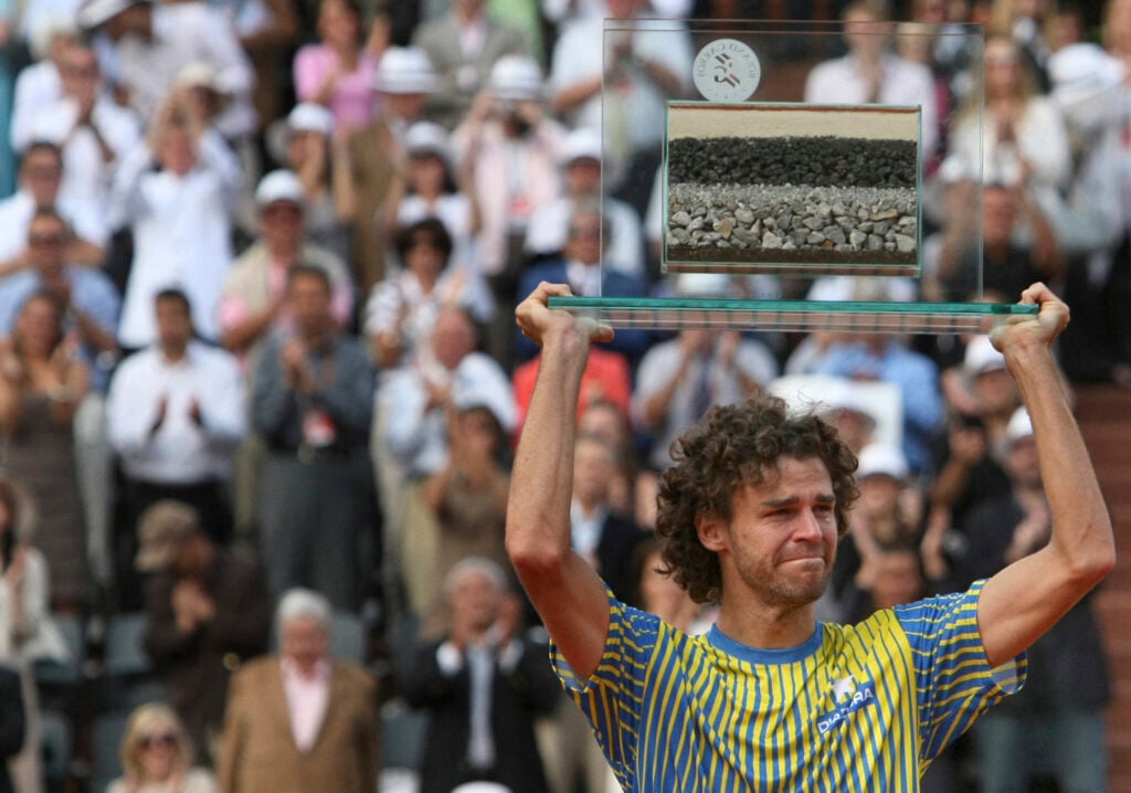 Brazilian player Gustavo Kuerten holds up a honorary trophy at the end of his French tennis Open first round match against French Paul-Henri Mathieu at Roland Garros, on May 25, 2008 in Paris. Former world No.1 Gustavo Kuerten retired from tennis after losing 6-3, 6-4, 6-2 to France's Paul-Henri Mathieu.