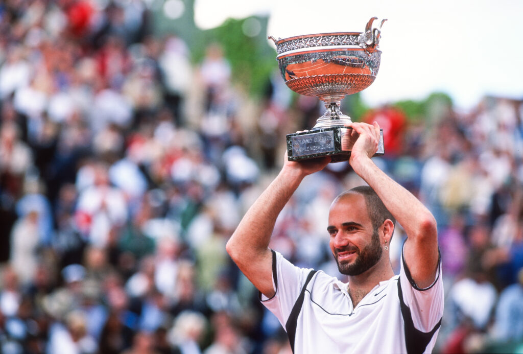 Andre Agassi of the USA lifts the trophy after defeating Andrei Medvedev of the Ukraine during the Men's Singles Final, during the French Open at Roland Garros on June 6th, 1999 in Paris, France.