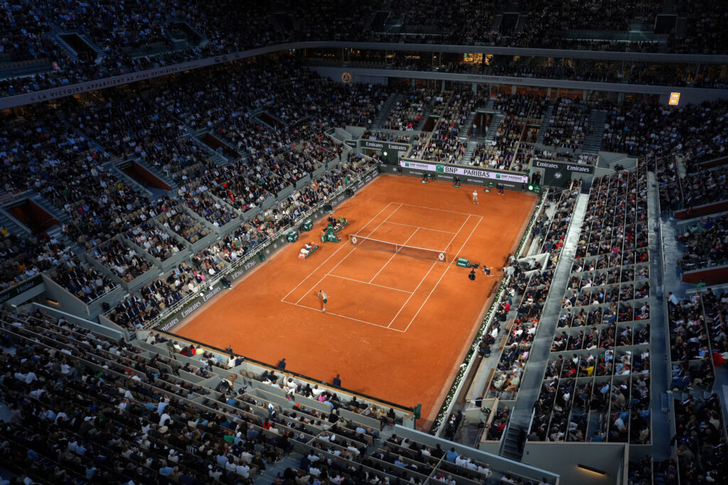 Spain's Carlos Alcaraz (front) serves to US Tommy Paul during their quarter-final men's singles match on day 10 of the French Open tennis tournament on Court Philippe-Chatrier at the Roland-Garros Complex in Paris on June 3, 2025.