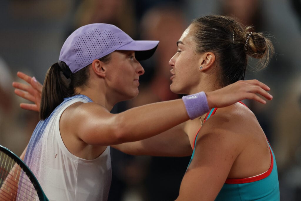 Belarus' Aryna Sabalenka (R) comforts Poland's Iga Swiatek after defeating her in their women's singles semi-final match on day 12 of the French Open tennis tournament on Court Philippe-Chatrier at the Roland-Garros Complex in Paris on June 5, 2025.