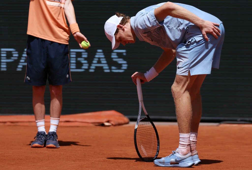 Italy's Jannik Sinner holds his glute as he stretches during his men's singles match against Argentina's Juan Manuel Cerundolo on day 5 of the French Open tennis tournament on Court Philippe-Chatrier at the Roland-Garros Complex in Paris on May 28, 2026.