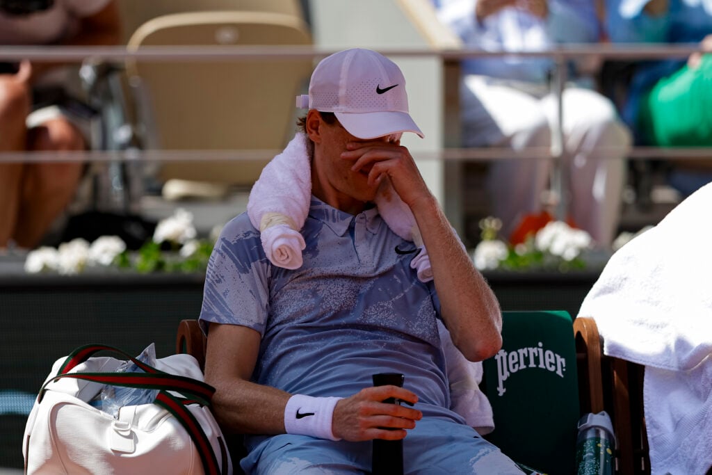 Jannik Sinner covers his face during defeat to Juan Manuel Cerundolo at the French Open.