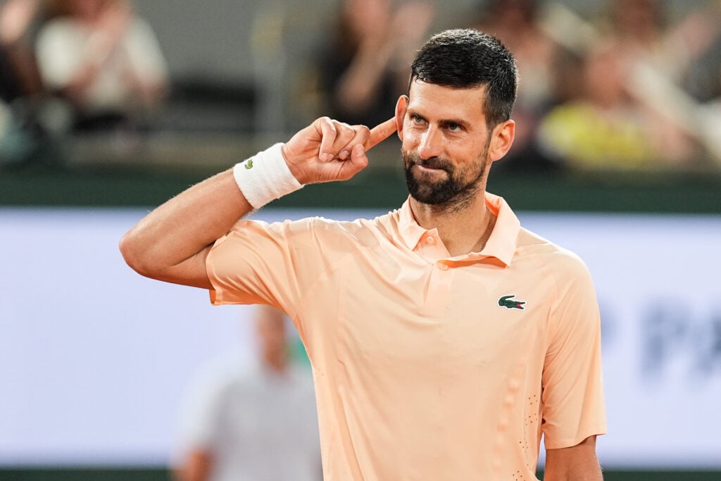 Novak Djokovic puts his finger to his ear