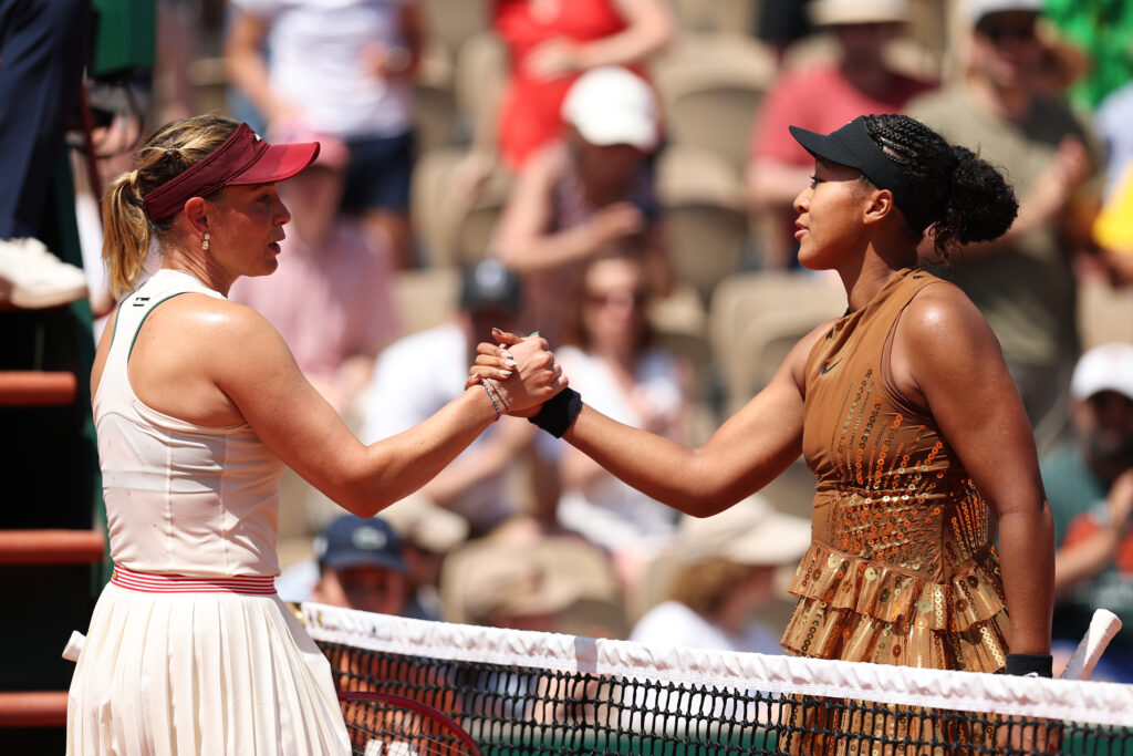 Naomi Osaka shakes Donna Vekic's hand after beating her at Roland Garros in 2026.