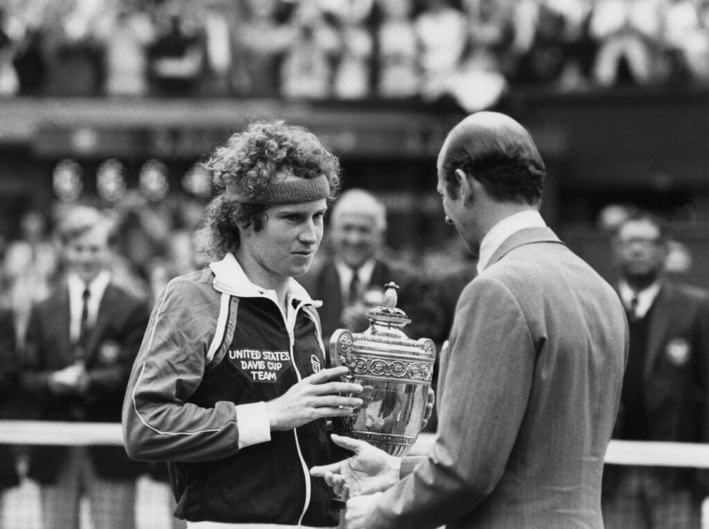 Prince Edward, Duke of Kent, presents the trophy to American tennis player John McEnroe after he beat Bjorn Borg to win the Men's Singles title on the Centre Court at Wimbledon, London, 4th July 1981.