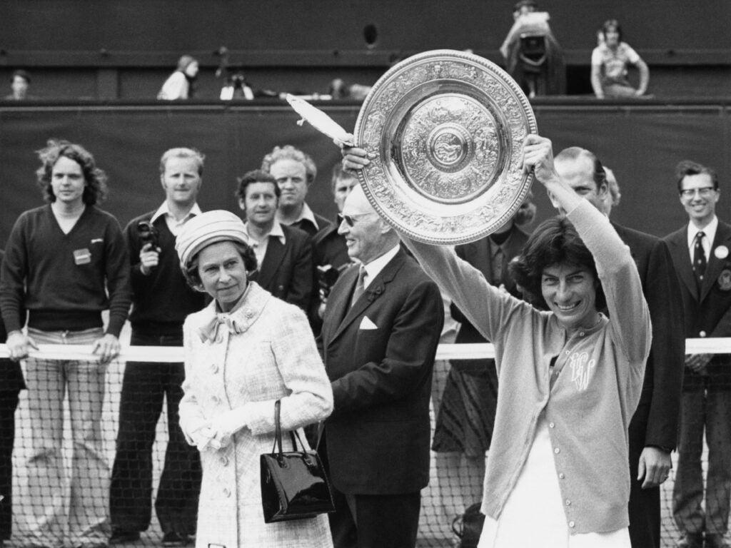 Queen Elizabeth II watches as the Women's Singles Champion, Virginia Wade from Britain, shows her trophy to the crowd on the centre court at Wimbledon, 1st July 1977. Wade has just beaten Betty Stove of the Netherlands in the final.