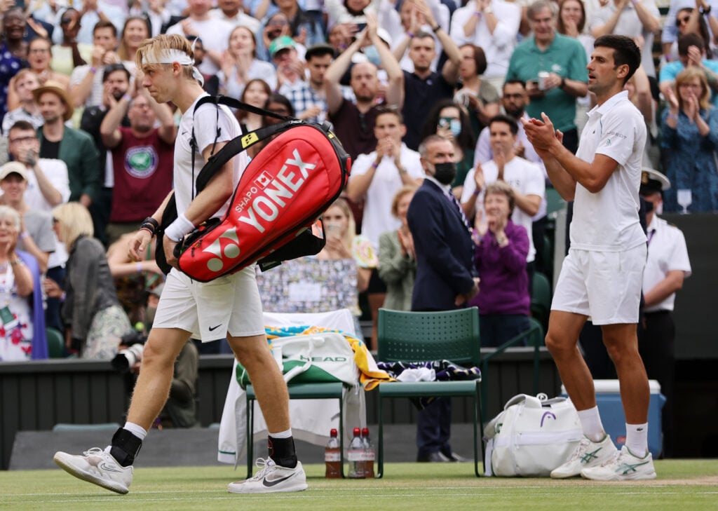 Novak Djokovic applauds Denis Shapovalov as he leaves the court at Wimbledon in 2021.