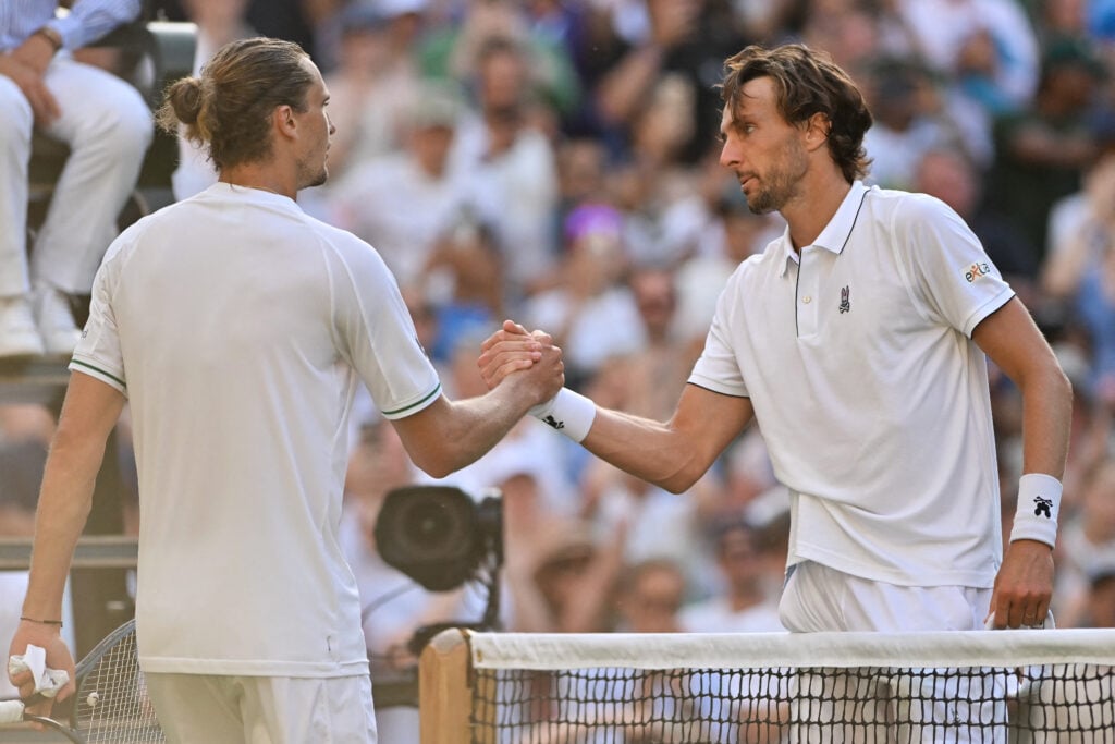 France's Arthur Rinderknech (R) shakes hands with Germany's Alexander Zverev after winning their men's singles first round tennis match on the second day of the 2025 Wimbledon Championships at The All England Lawn Tennis and Croquet Club in Wimbledon, southwest London, on July 1, 2025.