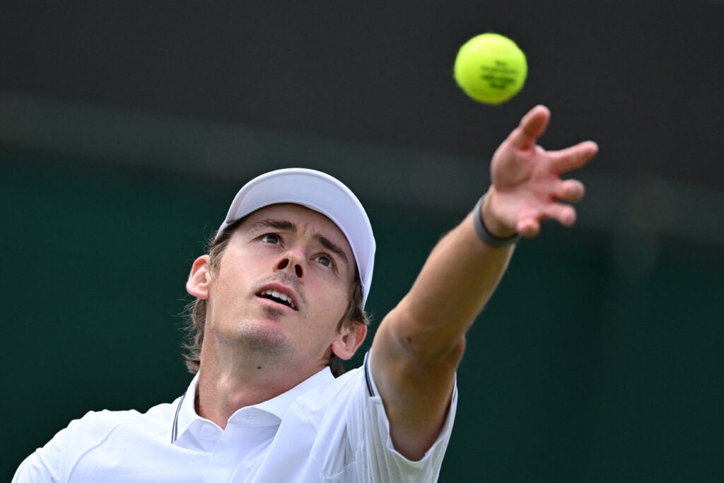 Australia's Alex De Minaur serves to Argentina's Roman Andres Burruchaga during their men's singles first round tennis match on the second day of the 2026 Wimbledon Championships at The All England Lawn Tennis and Croquet Club in Wimbledon, southwest London, on June 30, 2026.