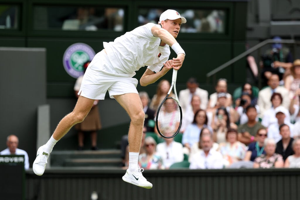 Jannik Sinner hits a serve during his first-round win at Wimbledon in 2026.