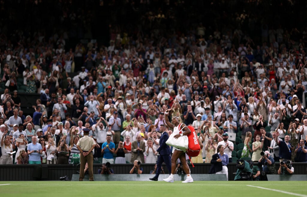 Serena Williams waves as she exits the court