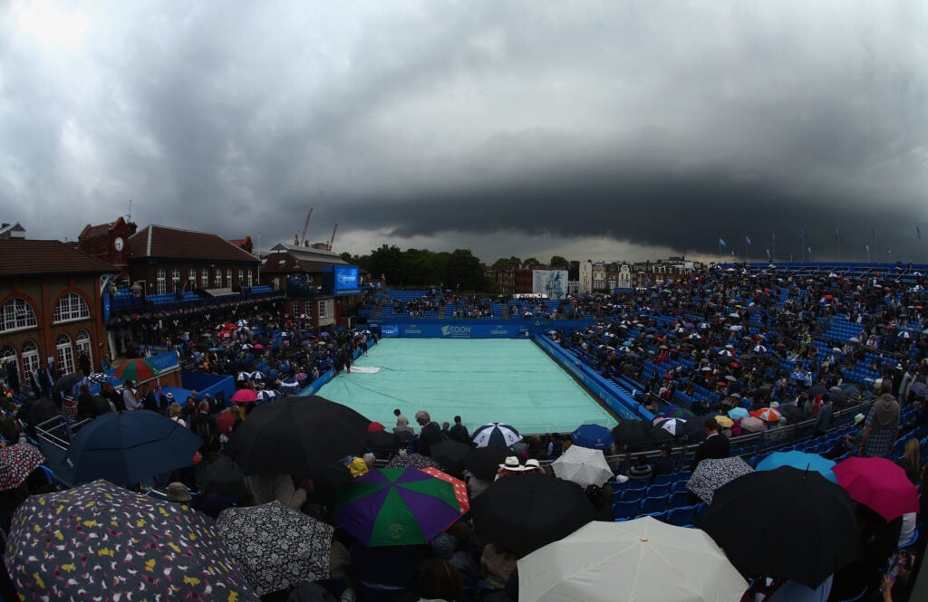 Spectators shelter from the rain as a dark rain cloud makes its way over centre court during the men's singles semi-final match between Andy Murray of Great Britain and Viktor Troicki of Serbia during day six of the Aegon Championships at Queen's Club on June 20, 2015 in London, England.