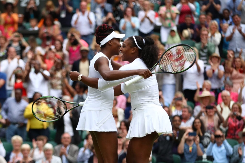 Venus Williams and Serena Williams celebrate at Wimbledon in 2016.
